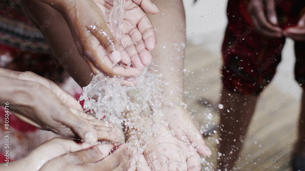 Stream of fresh water and the hands of people from a poor community