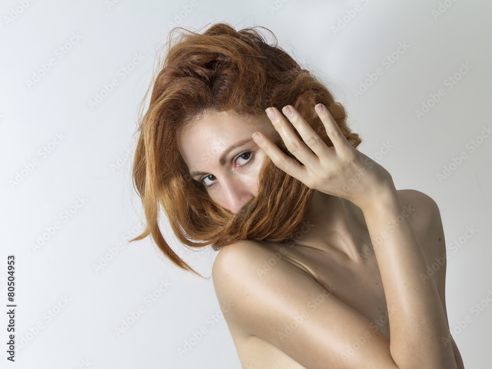 Woman covers her face with her red hair