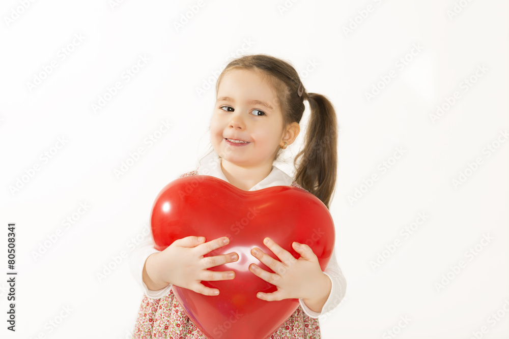 Laughing little girl holds red heart shape balloon Laughing little girl holds red heart shape balloon