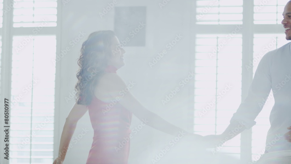 Happy and attractive young couple in love dance together in their apartment