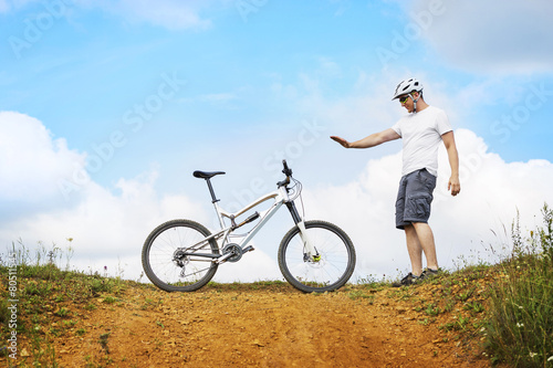 Fototapeta Naklejka Na Ścianę i Meble -  Biker showing stopping his mountain bike on a dolomite hill