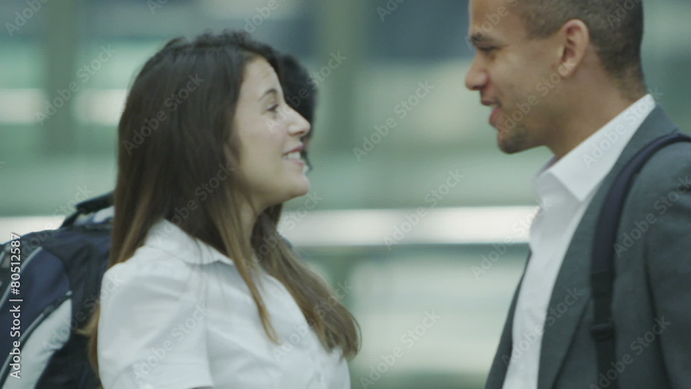 Businessman and businesswoman meet and shake hands at a busy railway station. Businessman and businesswoman meet and shake hands at a busy railway station.