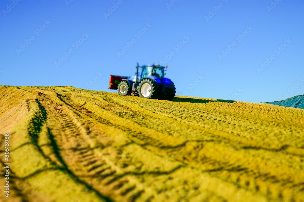 Fototapeta premium Schlepper auf einen Silohaufen, Tiltshift