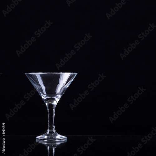 Empty glass of martini on black background