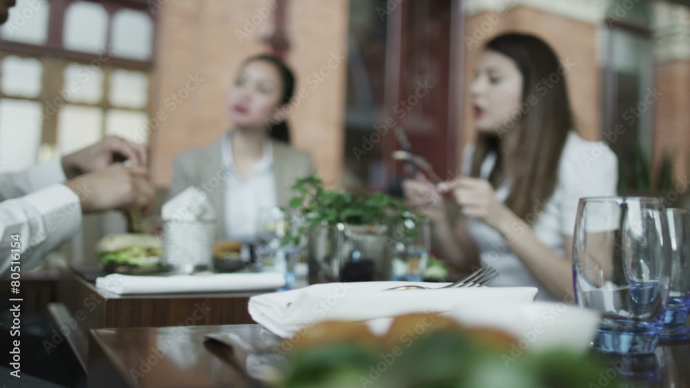 Cheerful group of friends chatting together at a restaurant Cheerful group of friends chatting together at a restaurant