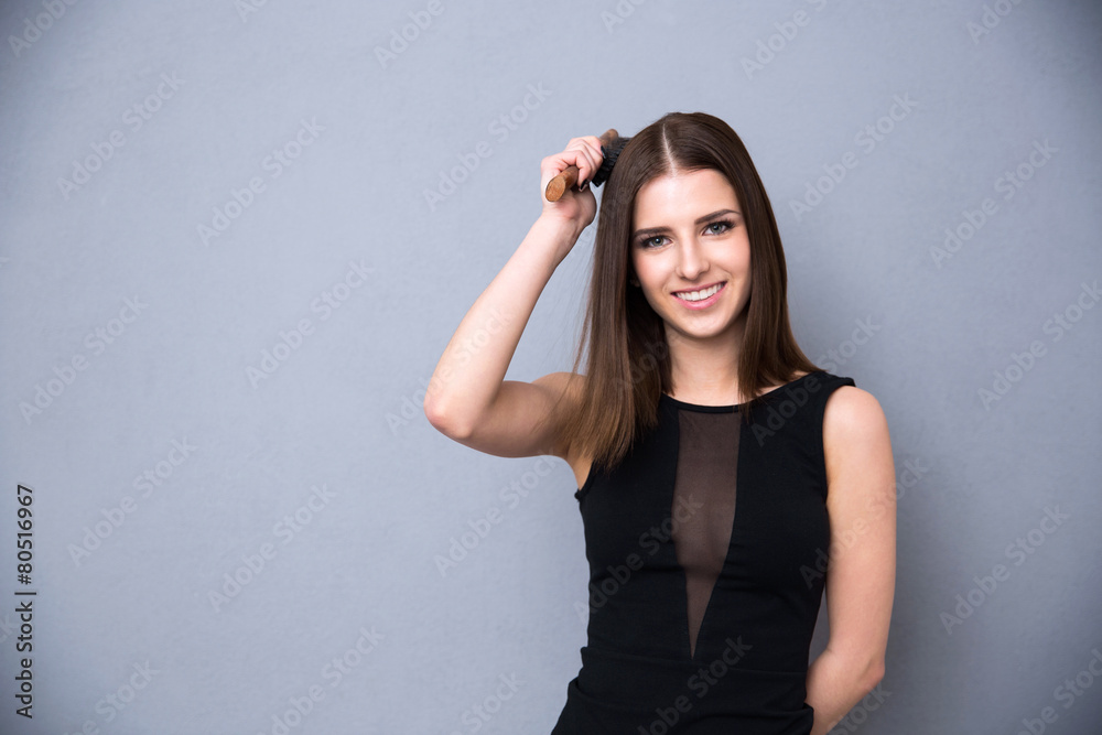 Happy cute woman combing her hair