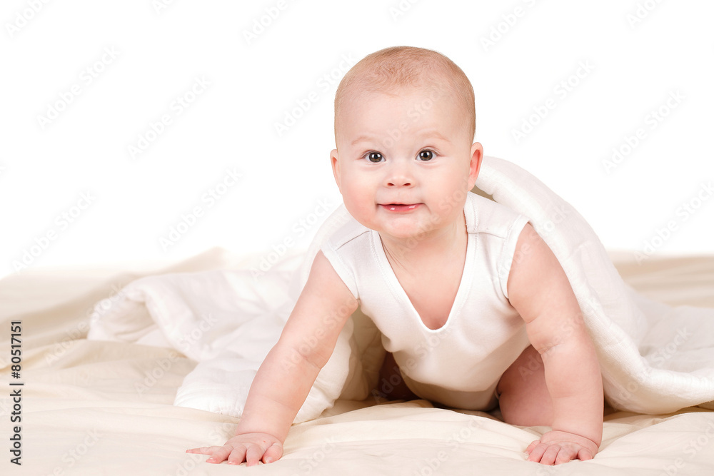 Cute baby peeking out from under the blanket,playing on the bed. Cute baby peeking out from under the blanket,playing on the bed.
