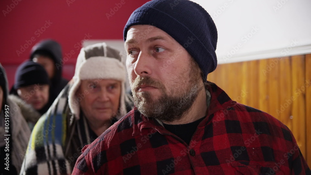Homeless and needy people, wrapped up warm against the cold are standing in line Homeless and needy people, wrapped up warm against the cold are standing in line