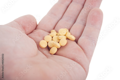 Hand holding yellow pills