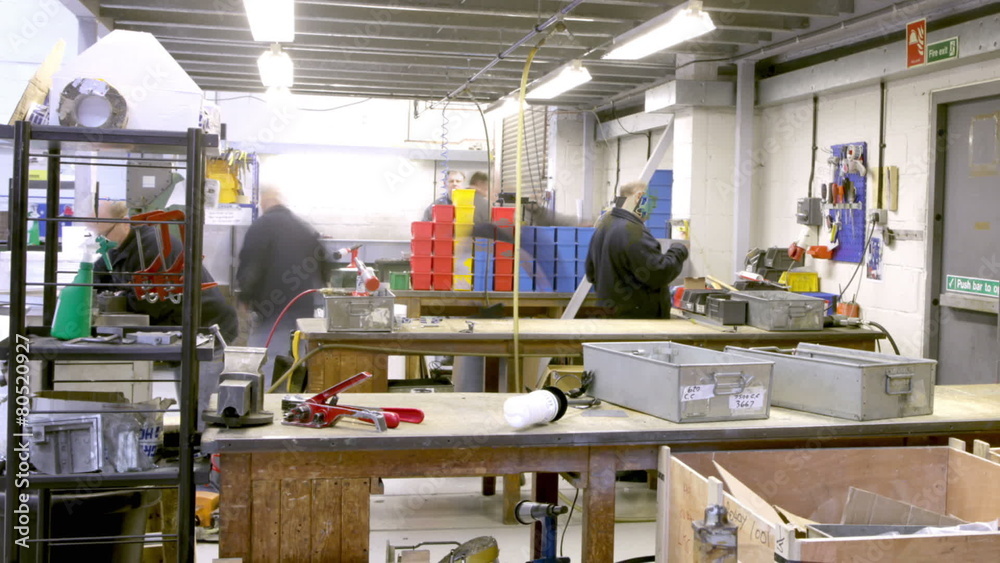 Time lapse clip of a busy team of manual workers in a factory or warehouse 