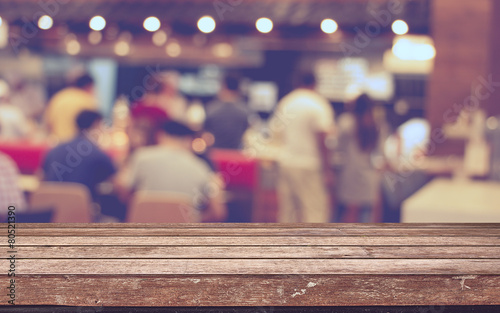 Empty wood table top with restaurant blur with bokeh