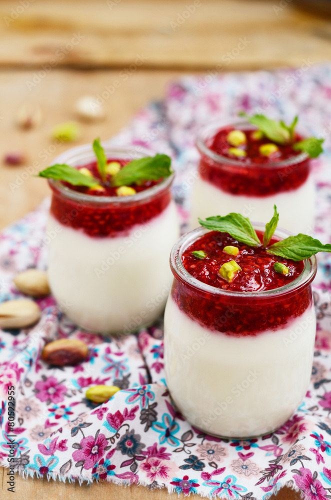 Homemade yogurt with raspberry and pistachio in glass jars Homemade yogurt with raspberry and pistachio in glass jars