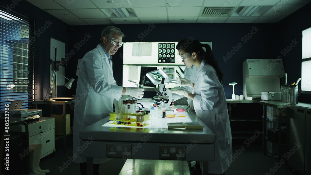 Zoom out from medical research team working together in a laboratory Zoom out from medical research team working together in a laboratory