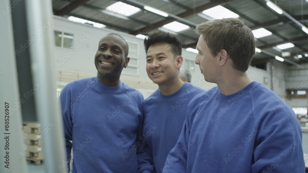 Cheerful factory or warehouse workers checking the machinery Cheerful factory or warehouse workers checking the machinery