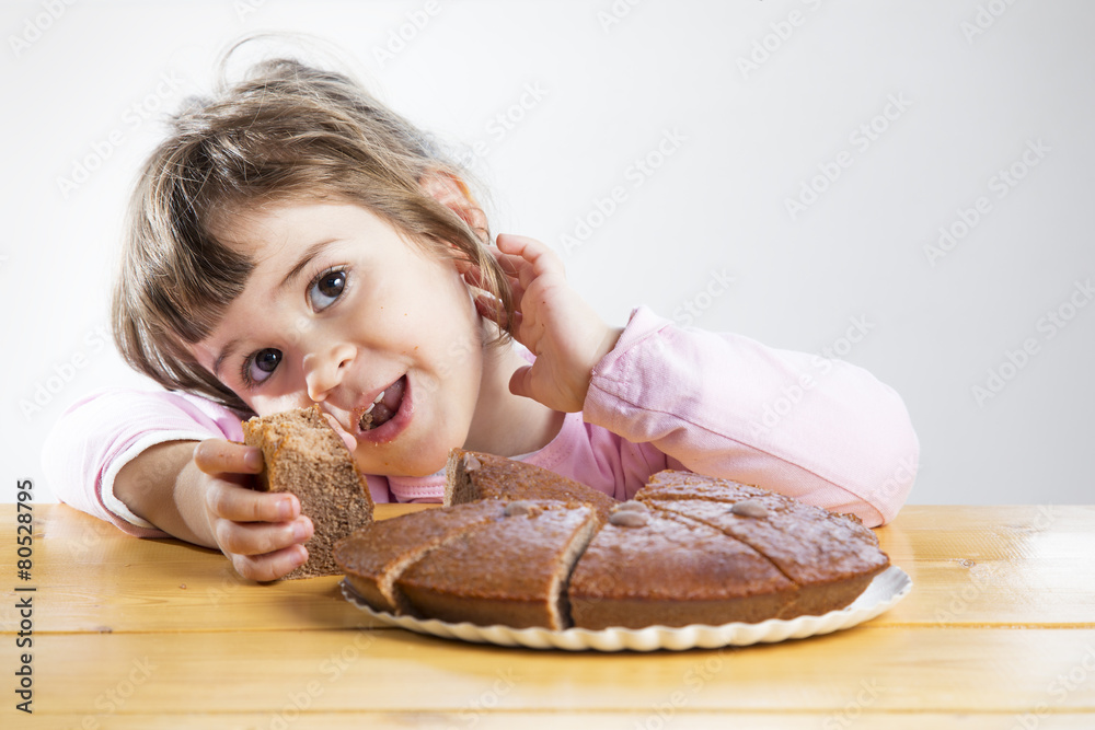 Adorable little girl eating a homemade chocolate cake Adorable little girl eating a homemade chocolate cake