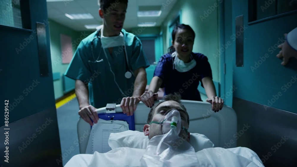 Medical staff transport a patient in serious condition on a hospital gurney