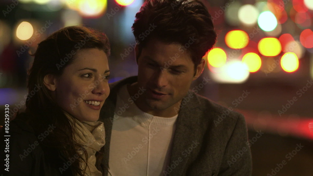 A happy couple in an embrace spend time together talking in the city at night A happy couple in an embrace spend time together talking in the city at night
