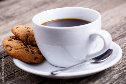 Cup of coffee with cookies on a table.