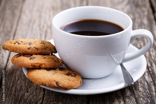 Cup of coffee with cookies on a table.