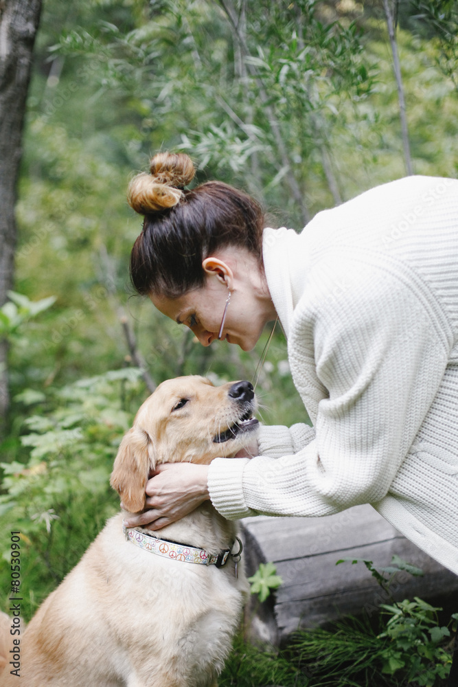A woman petting her dog. 