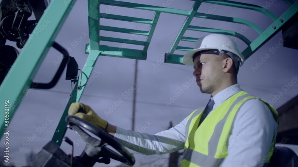A forklift truck driver manoeuvring his truck through the doors of a warehouse