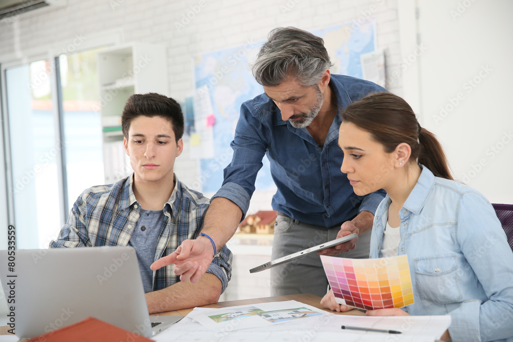 Teacher with students in architecture school