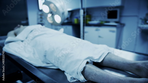 Dead male body laid out on an autopsy table photo