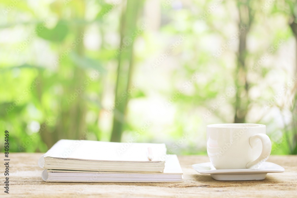 Notebook and white cup on wooden table Notebook and white cup on wooden table
