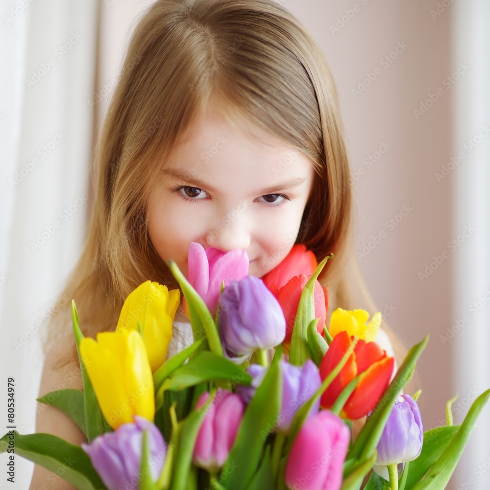 © MNStudio - Adorable little girl holding tulips by the window