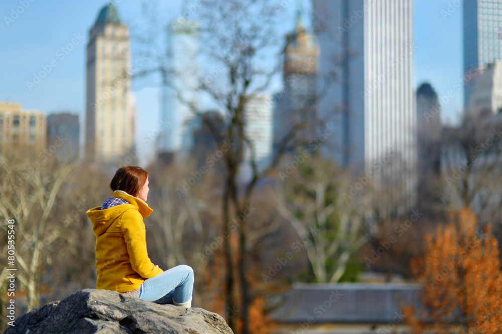 Young woman looking at skyscrapers in Central Park Young woman looking at skyscrapers in Central Park
