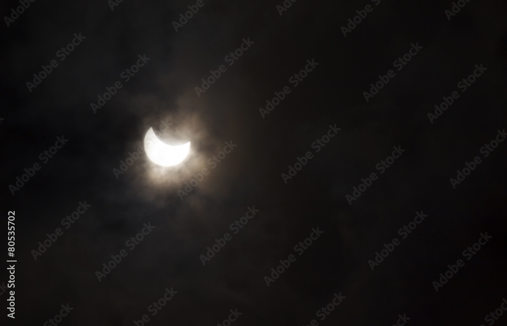 view on partial solar eclipse behind clouds