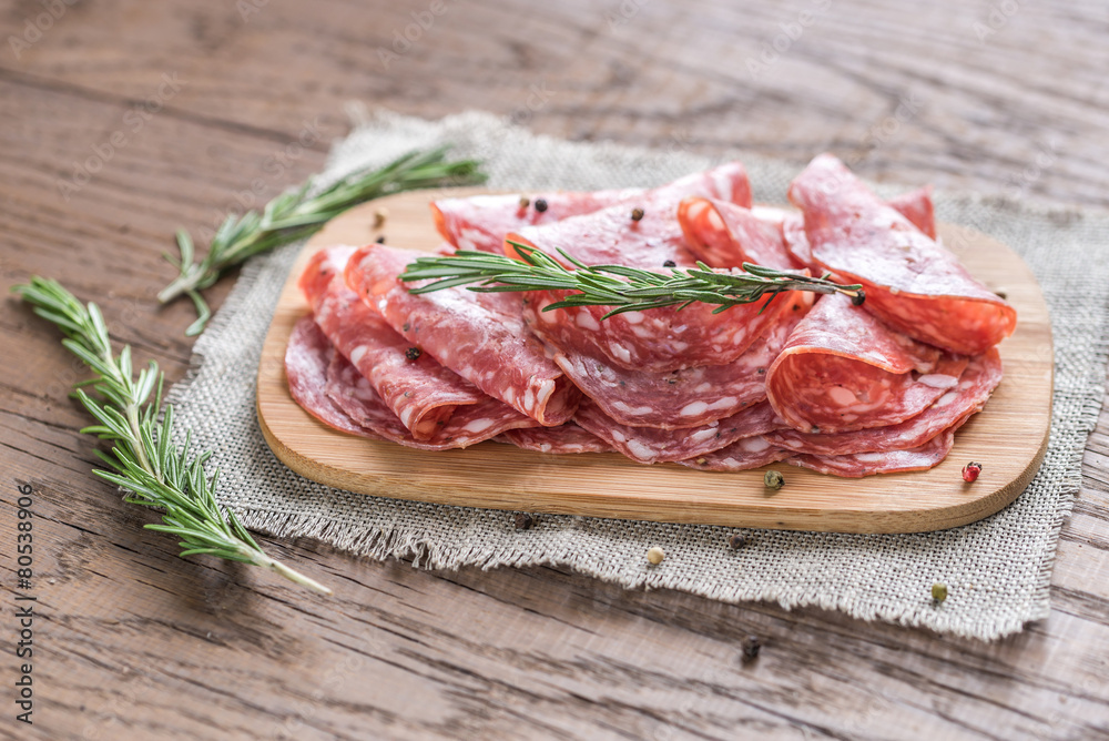 Slices of salami on the wooden board Slices of salami on the wooden board