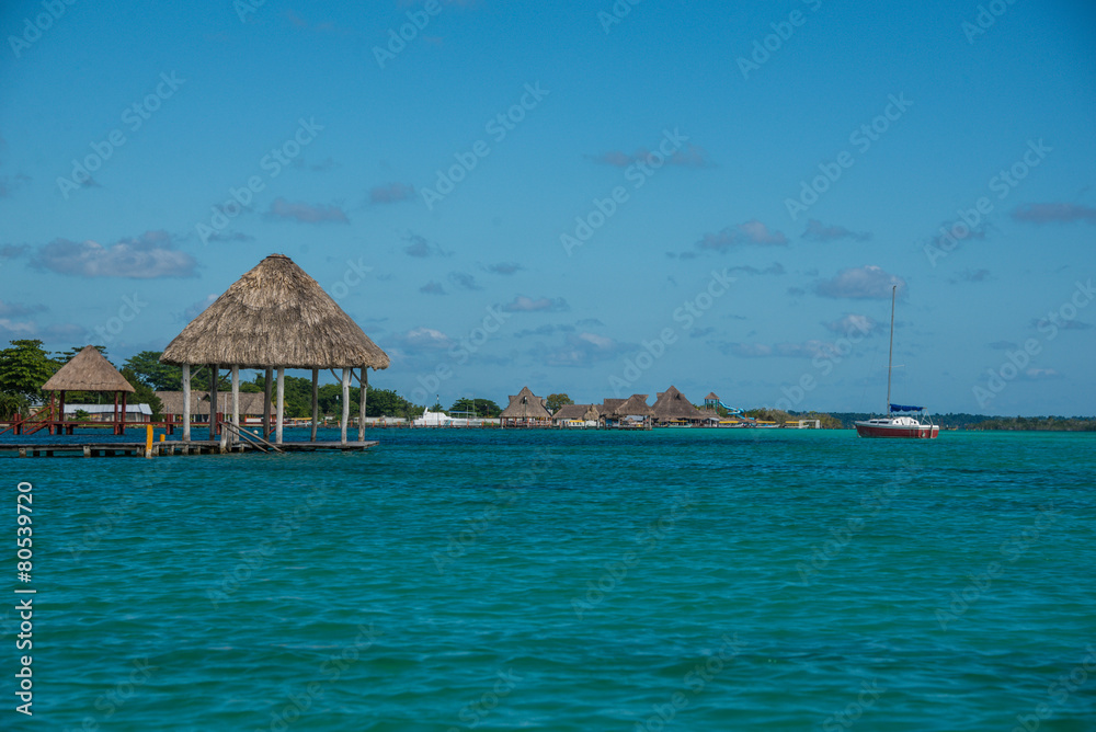 Caribbean scene with hut and Sailboat. Bacalar, near tulum. Trav