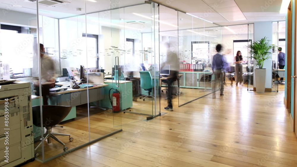Time lapse of busy business group working in contemporary office building
