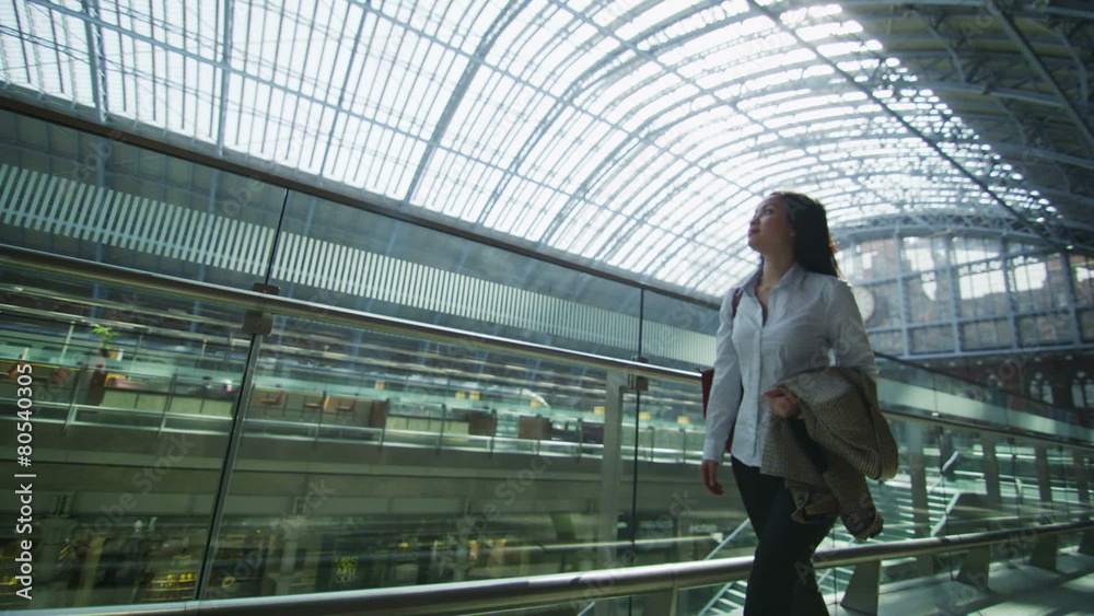 Beautiful woman traveling alone walks through iconic London railway station Beautiful woman traveling alone walks through iconic London railway station
