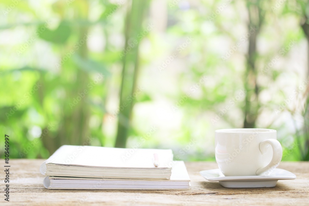 Notebook and white cup on wooden table Notebook and white cup on wooden table