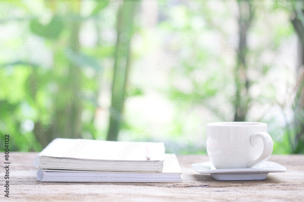 Notebook and white cup on wooden table Notebook and white cup on wooden table