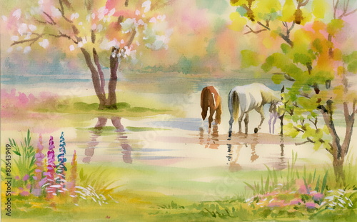 Two horses graze among the trees in the garden