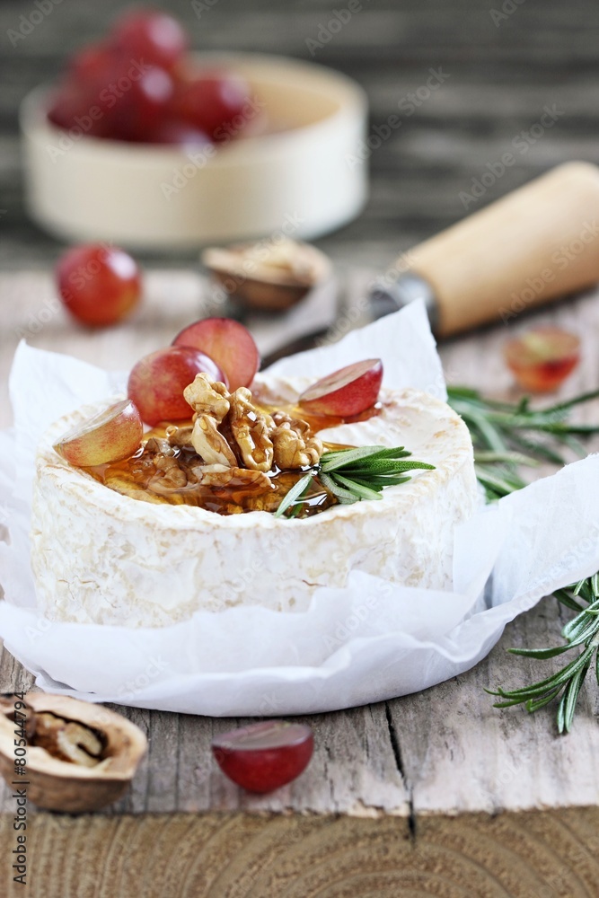 Camembert with walnuts and honey on a rustic wooden table. Camembert with walnuts and honey on a rustic wooden table.