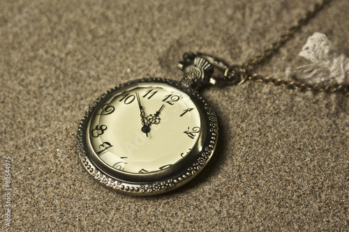 antique clock in the sand