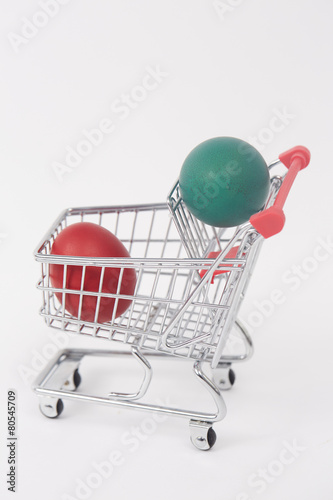 Easter colorful painted eggs in the shopping cart and near the t