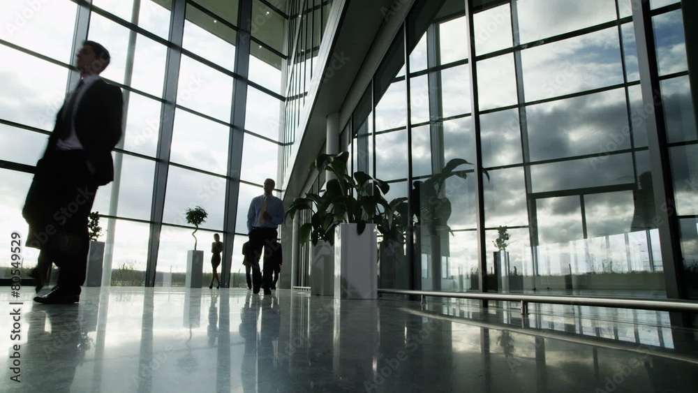 Time lapse of business people and clouds in a light and modern office building