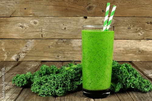 Healthy green smoothie with kale in a glass against rustic wood