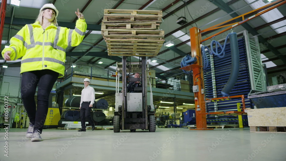 Team of busy warehouse workers lifting and moving empty wooden pallets Team of busy warehouse workers lifting and moving empty wooden pallets
