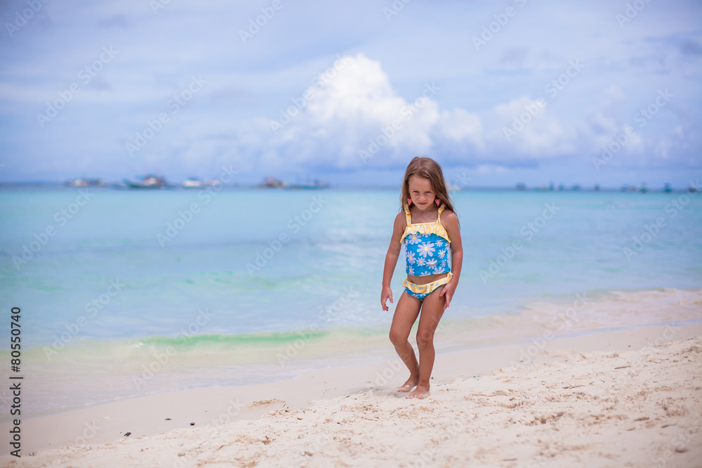 Adorable little girl have fun at tropical beach during vacation