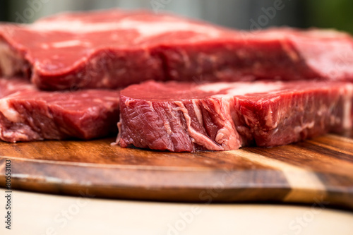 Fresh beef steaks on wooden board