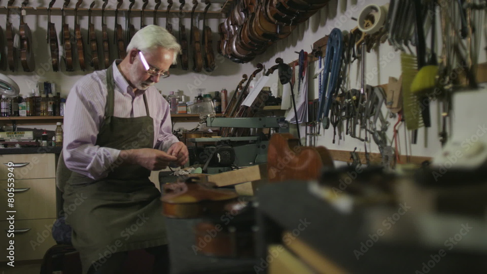 Father and son shopping together, looking at violins in a musical store Father and son shopping together, looking at violins in a musical store