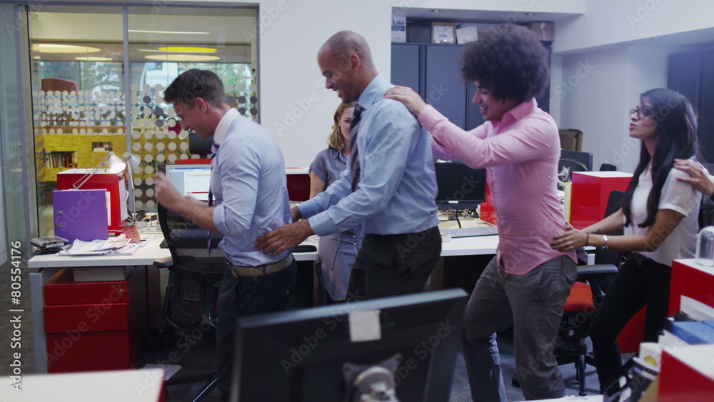 Funny business team doing a conga line through their office.