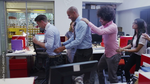 Funny business team doing a conga line through their office.