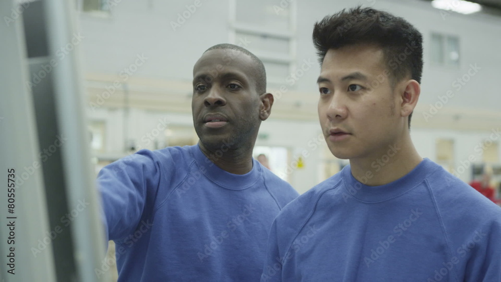 Cheerful factory or warehouse workers checking the machinery Cheerful factory or warehouse workers checking the machinery